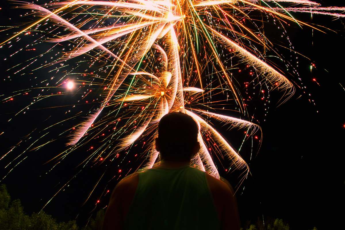 night man watching over firework display during nighttime outdoors