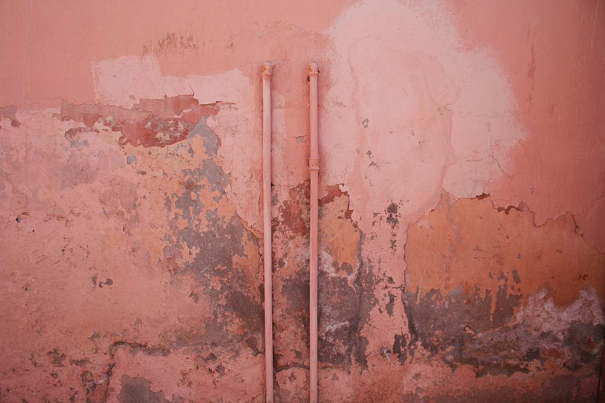 pink water hose on wall texture