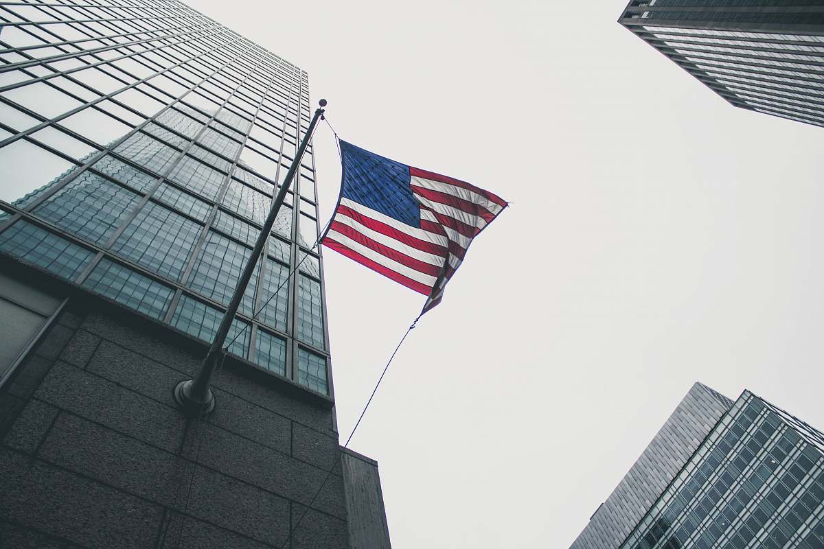 building flag of America waving under gray skies skyscraper