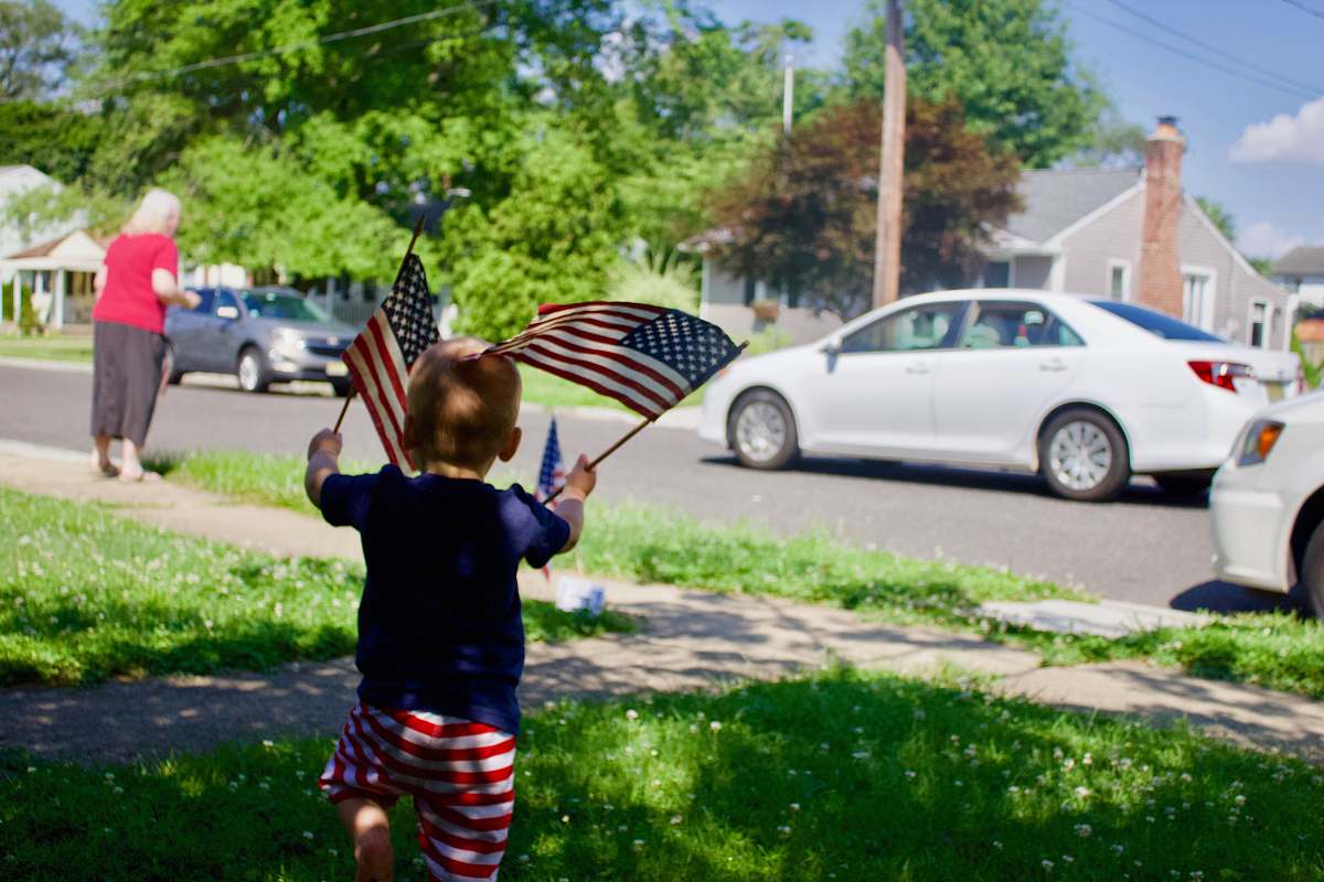 symbol kid holding America flag during daytime human