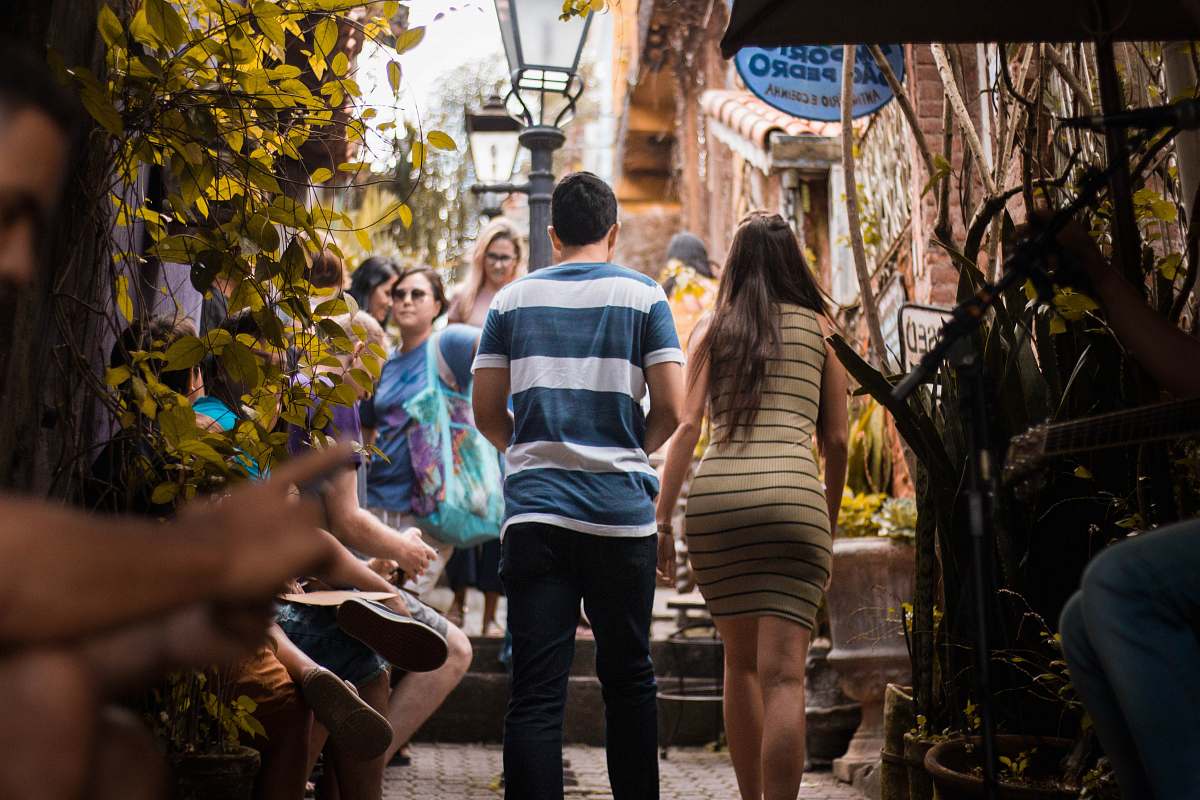 human man wearing blue and white stripe shirt besides woman wearing brown and black stripe body con dress apparel