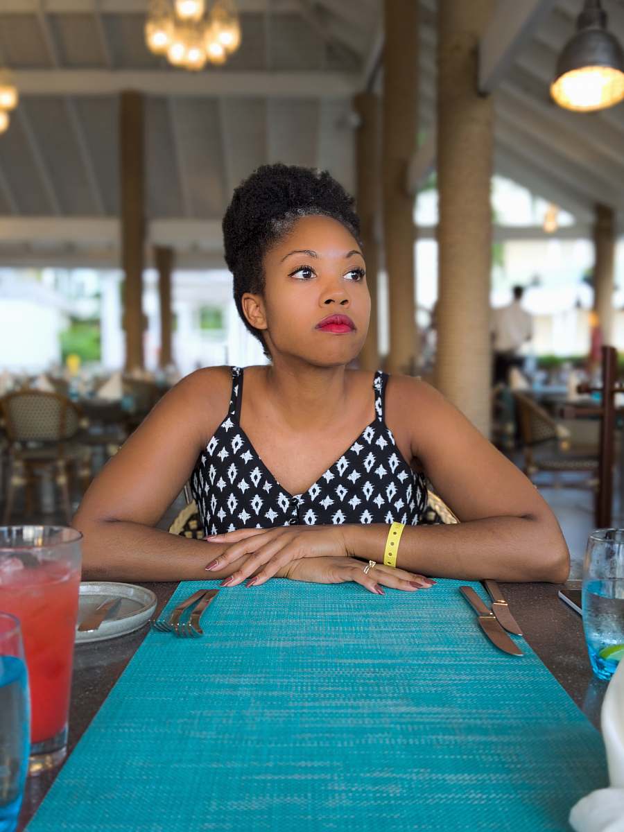 A stylish woman dressed in a black and white outfit sits at a beautifully set table in a modern restaurant, her hands gracefully resting on the surface as she enjoys a delicious plate of spaghetti. This image captures the essence of fine dining and culinary appreciation, making it perfect for food bloggers, restaurant advertisements, and lifestyle magazines looking to convey sophistication and gastronomy.
