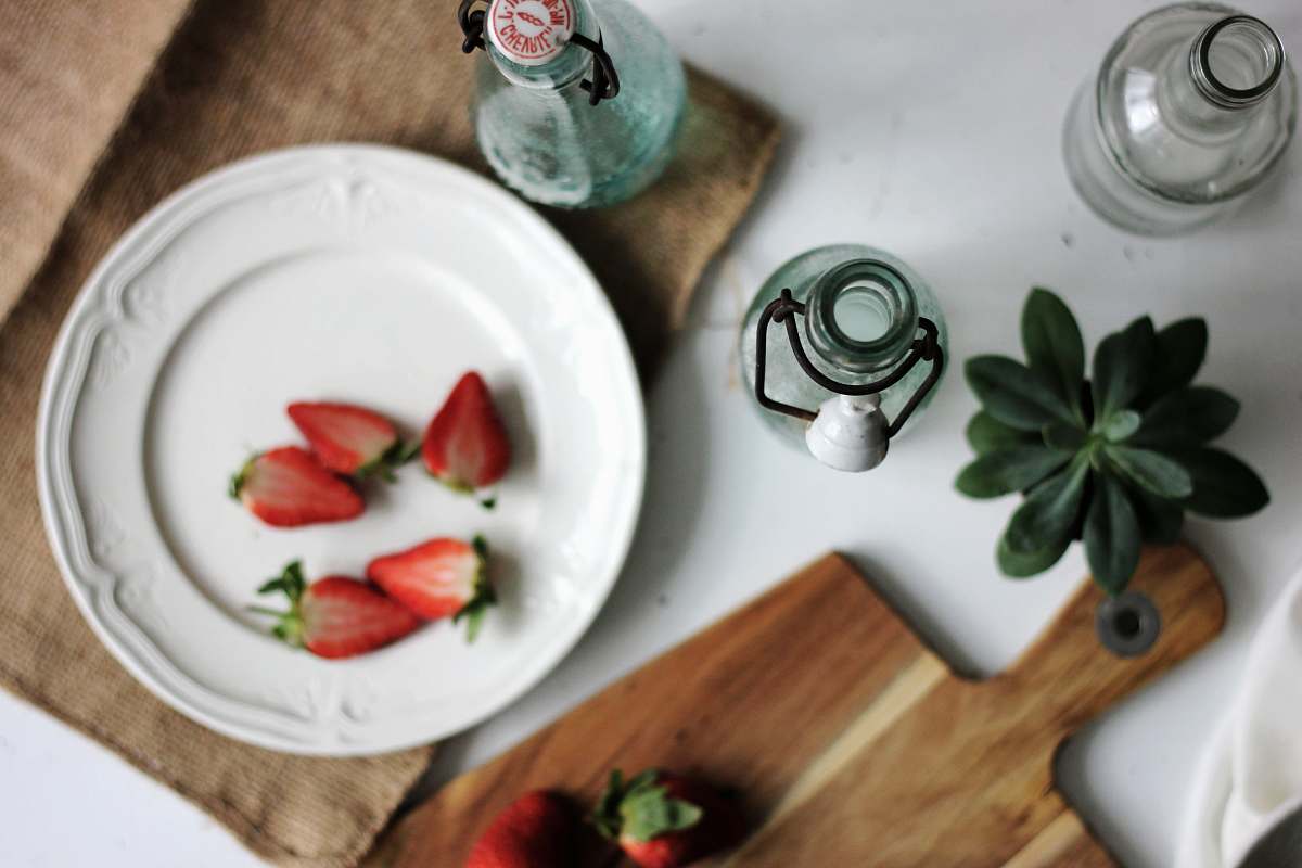 bottle fruits on plate with bottles on white table strawberry
