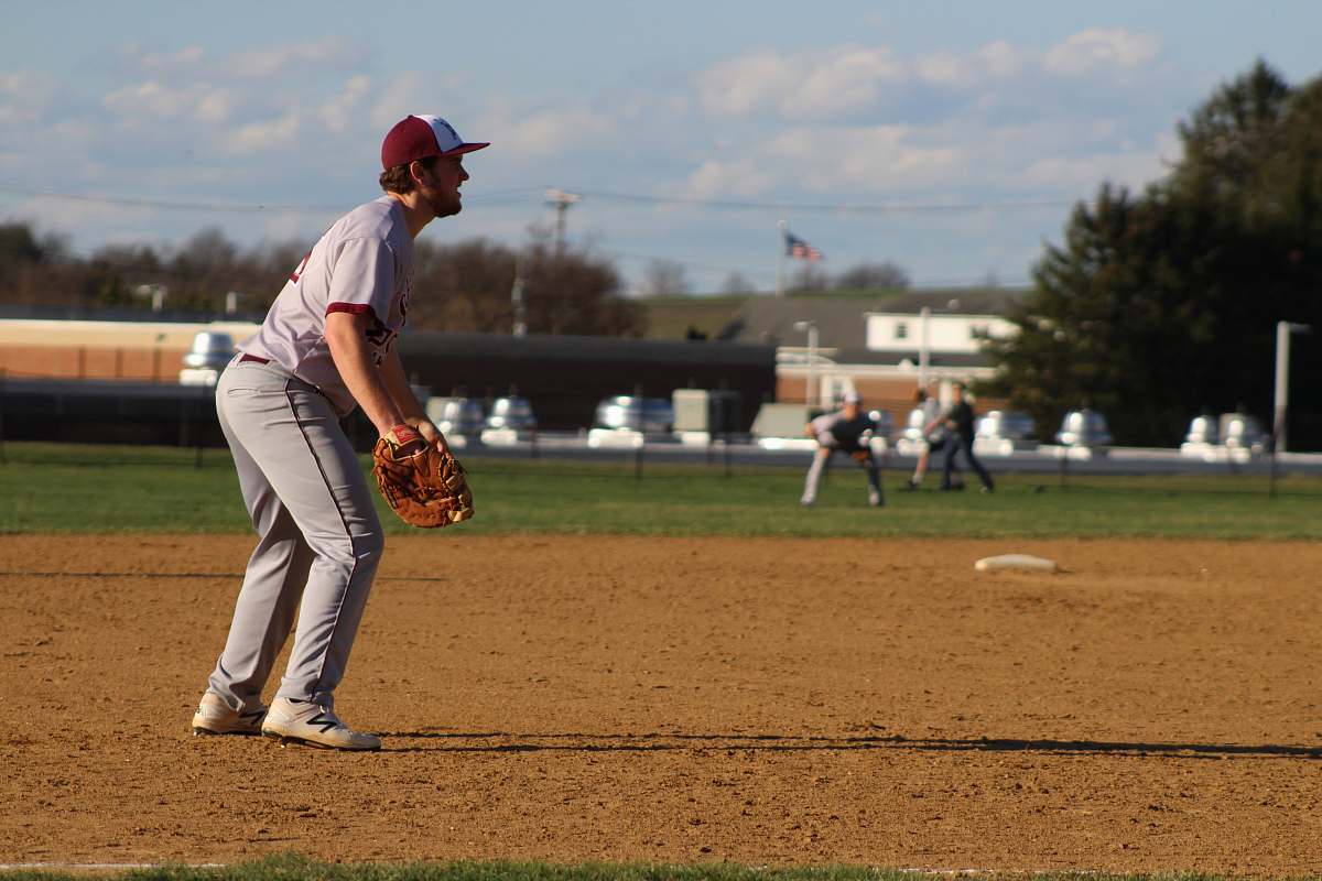 sports man in red baseball jersey and white pants standing on field during daytime apparel