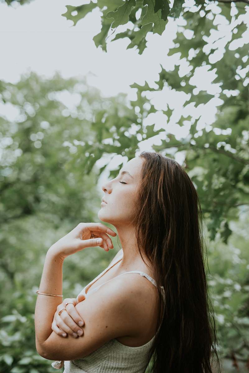 Experience the serenity of nature with this captivating image of a woman standing among tall trees, eyes closed in a moment of relaxation. This scene captures the essence of peace and connection with the outdoors, making it perfect for wellness blogs, meditation guides, or any content focused on relaxation and self-care. The soft light filtering through the leaves adds a magical touch, inviting viewers to immerse themselves in the tranquility of the forest.