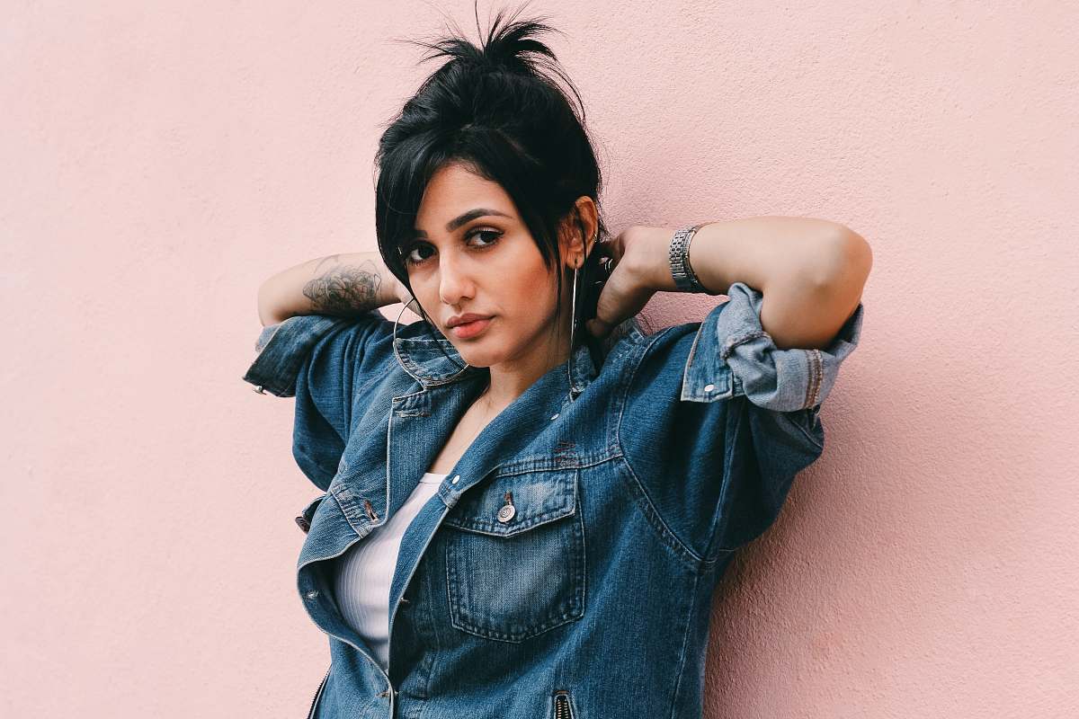 woman Woman wearing a denim wall leaning against a millennial pink wall human