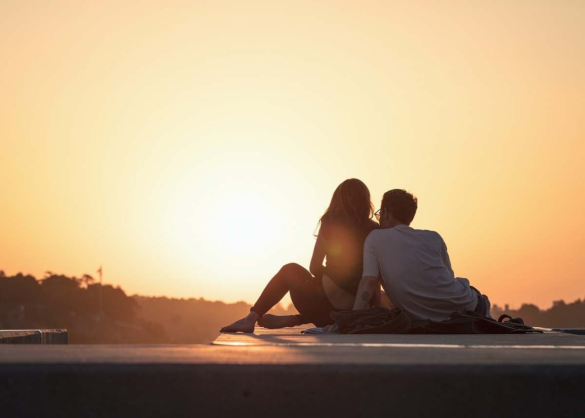 people couple sitting near trees during golden hour couple