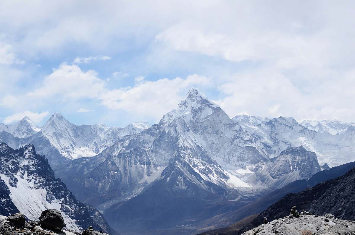 nature aerial photography of mountain range covered with snow under white and blue sky at daytime outdoors
