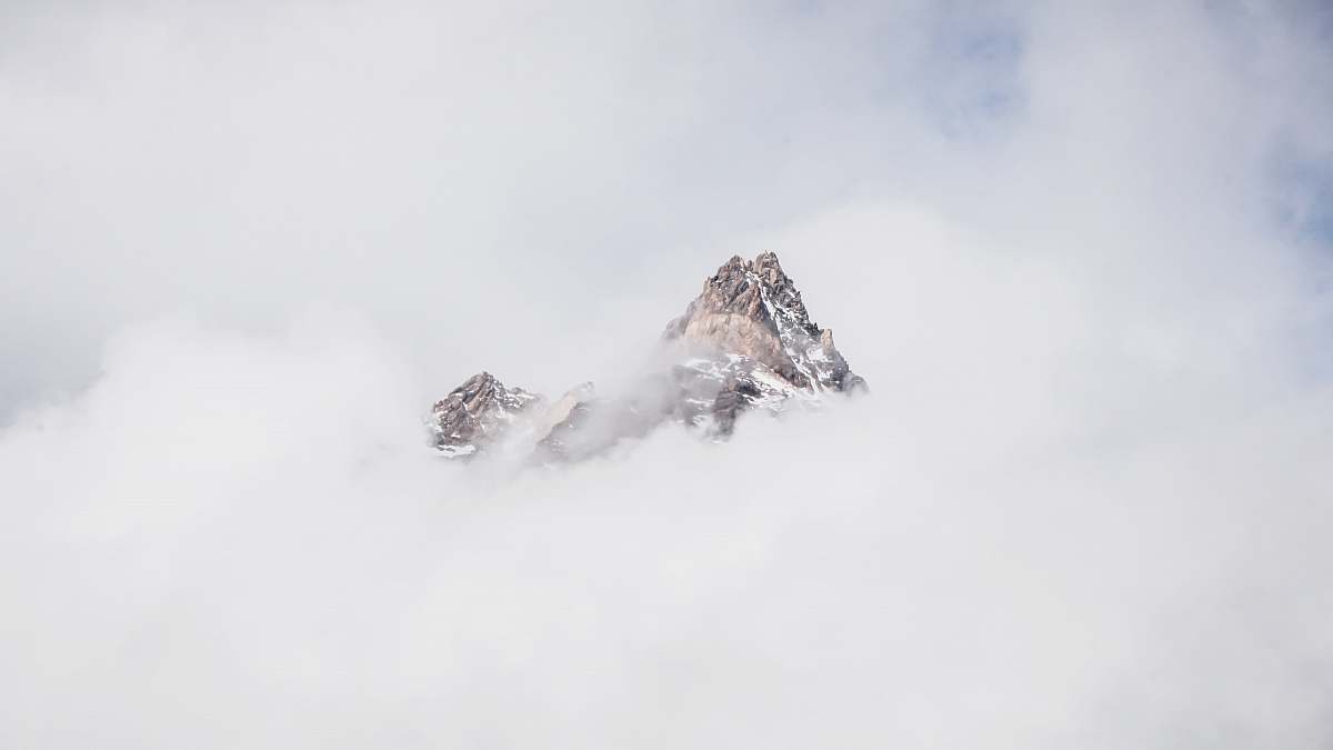 grey snow mountain covered with clouds peak