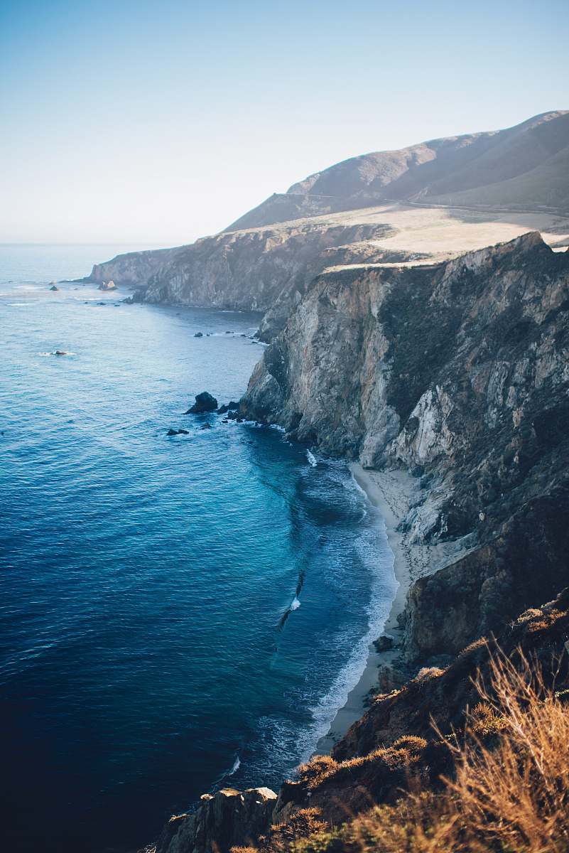 Capture the breathtaking beauty of the ocean as it crashes against the rugged cliffs in this stunning photo. This image presents a panoramic view that highlights the contrast between the deep blue waters and the rocky shore, making it perfect for travel blogs, nature magazines, and coastal decor. Ideal for anyone looking to evoke a sense of adventure and serenity, this photograph invites viewers to explore the untamed beauty of the sea.