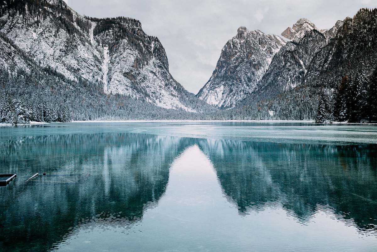 nature body of water and snow-covered mountains during daytime snow
