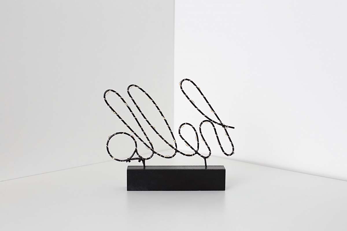Discover a striking black sculpture adorned with the word 'hello' in a unique handwritten style. This eye-catching piece of art combines modern design with a warm greeting, making it perfect for decor in cafs, offices, or as part of a contemporary art exhibit. Ideal for use in promotional materials, social media posts, or as a backdrop for events, this sculpture brings a friendly and artistic touch to any setting.