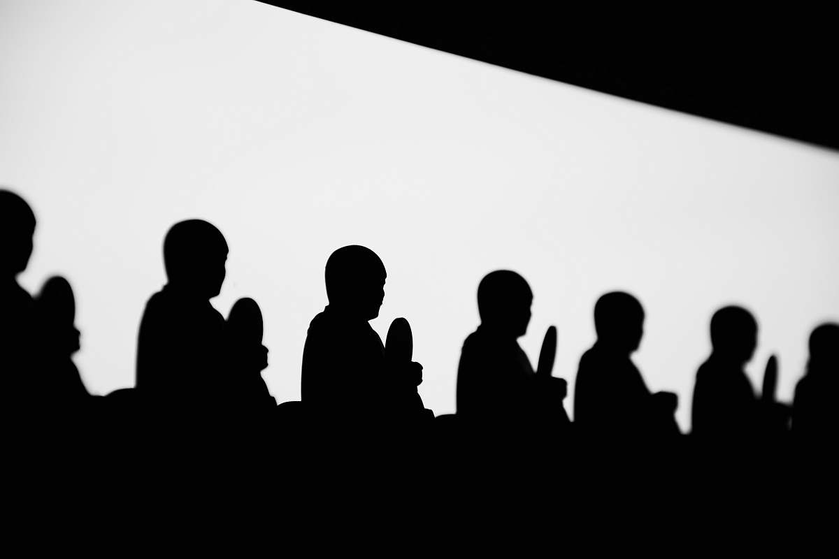 black-and-white silhouette of praying people audience