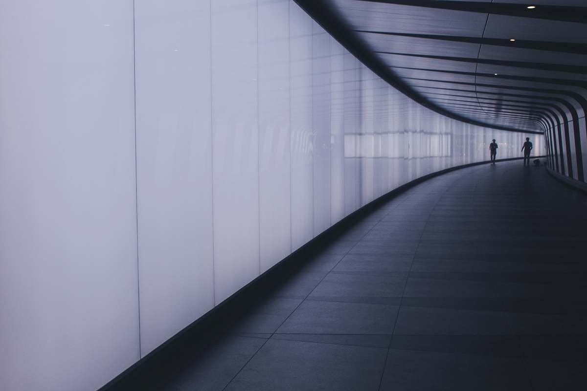  two people walking in hallway 