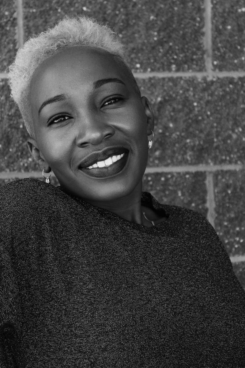 clothing smiling woman by wall black-and-white