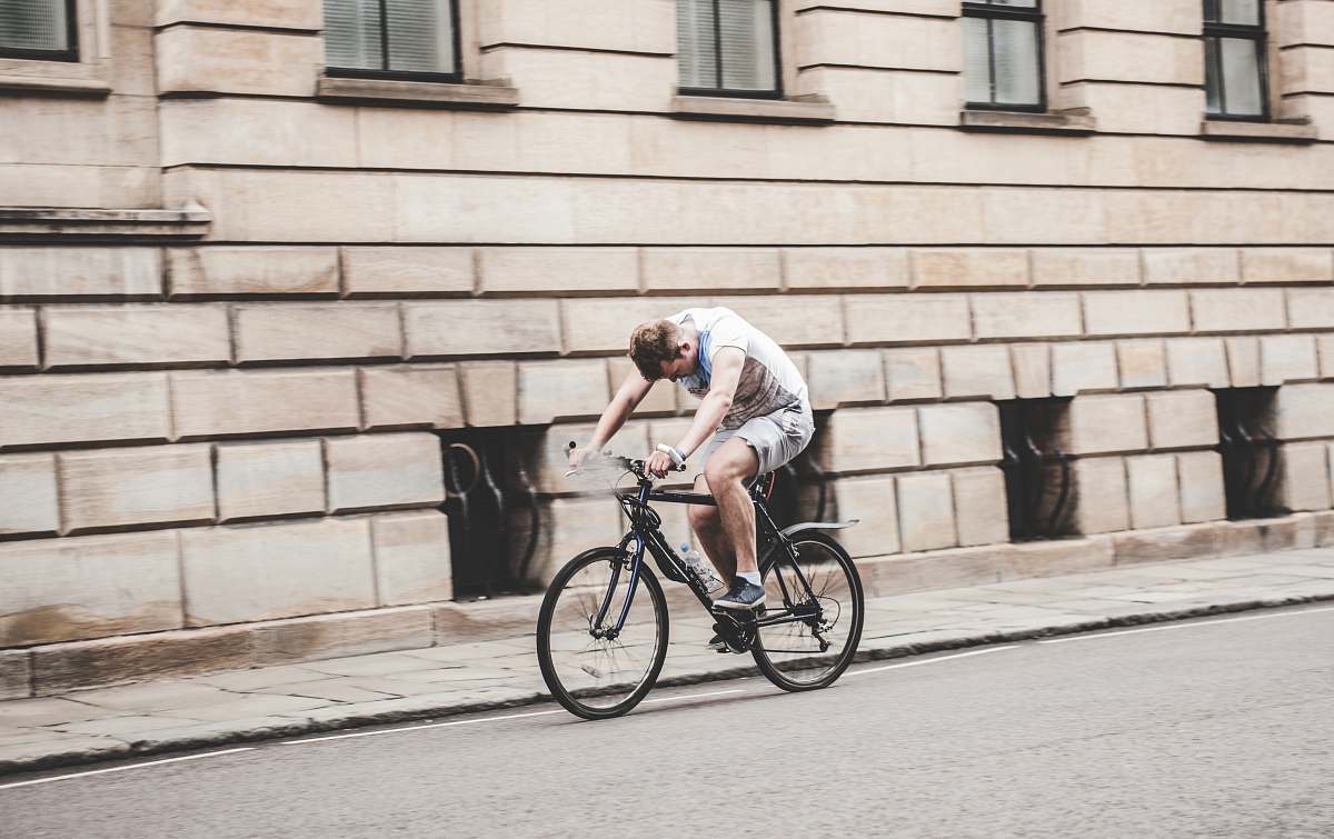 bicycle man wearing gray t-shirt and gray shorts cycling bike