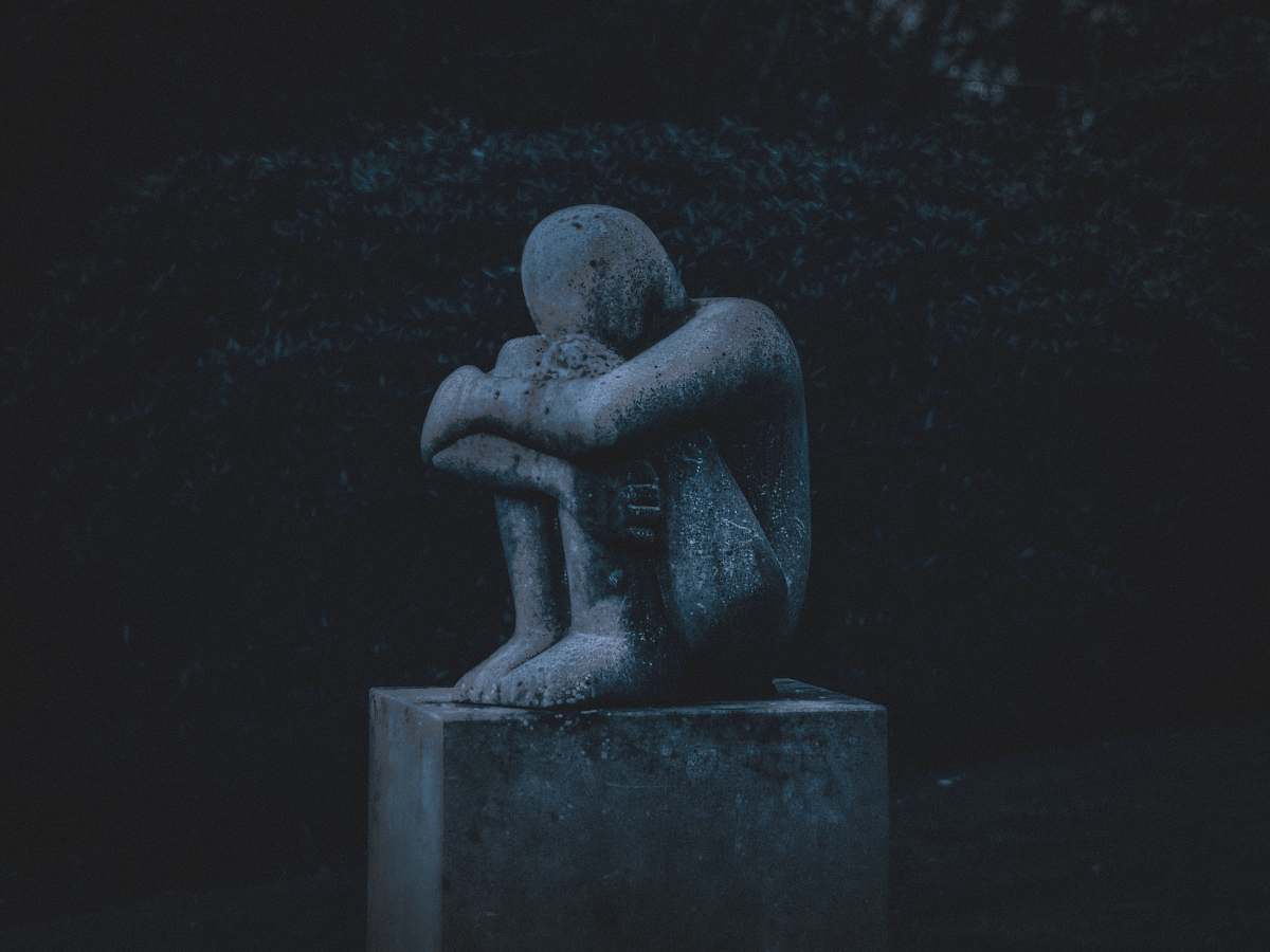 hydrant man hugging his knee statue fire hydrant