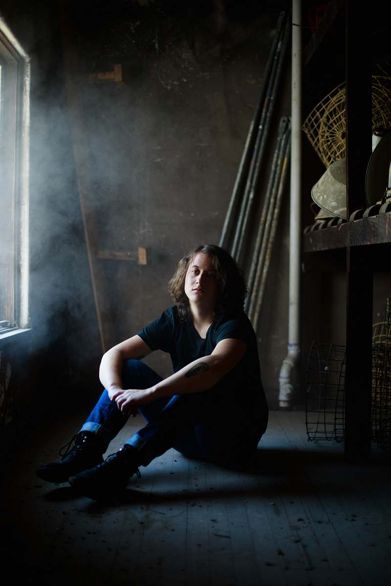 person man sitting while resting his arms on his knee inside concrete building human