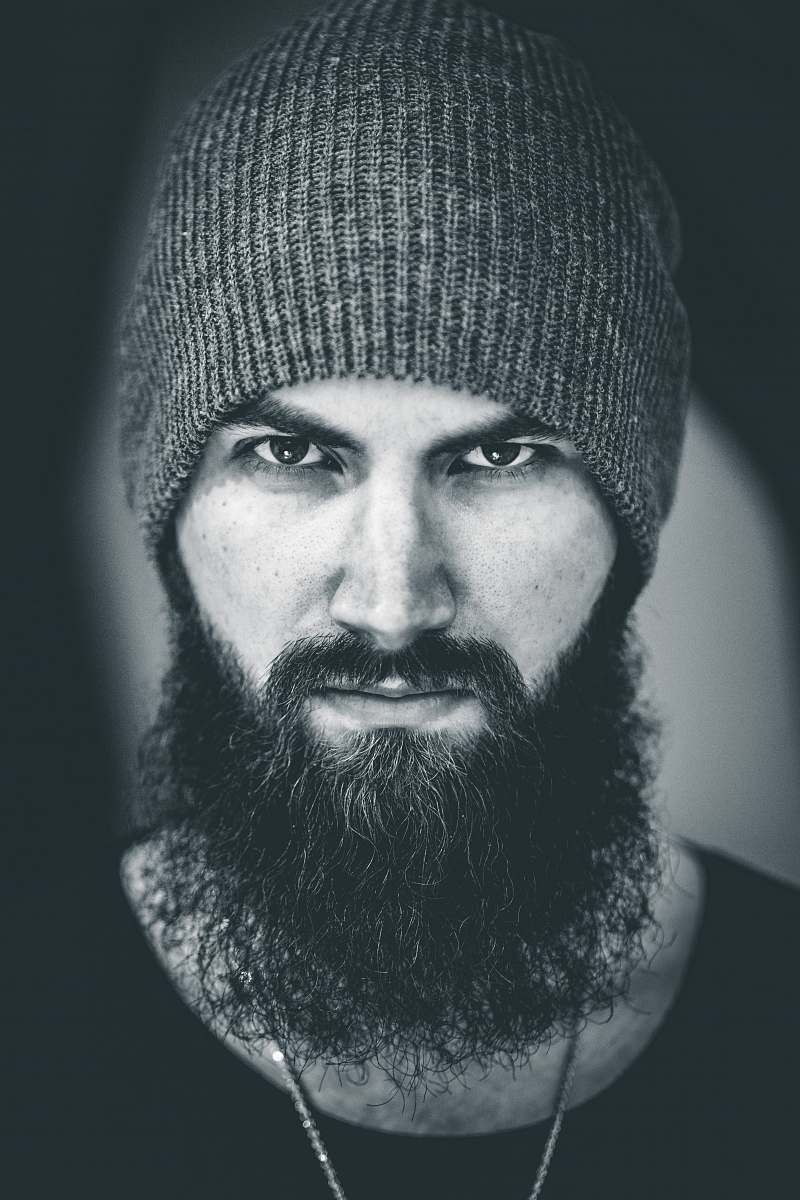 human man in beanie starring face