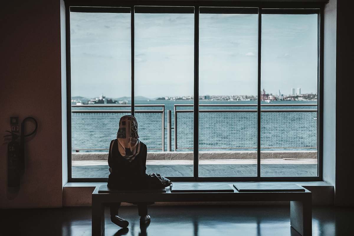 human person sitting on bench watching sea floor