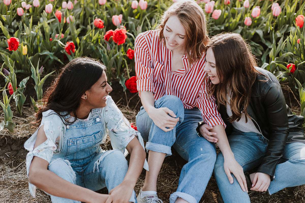human three woman sitting near the flower footwear