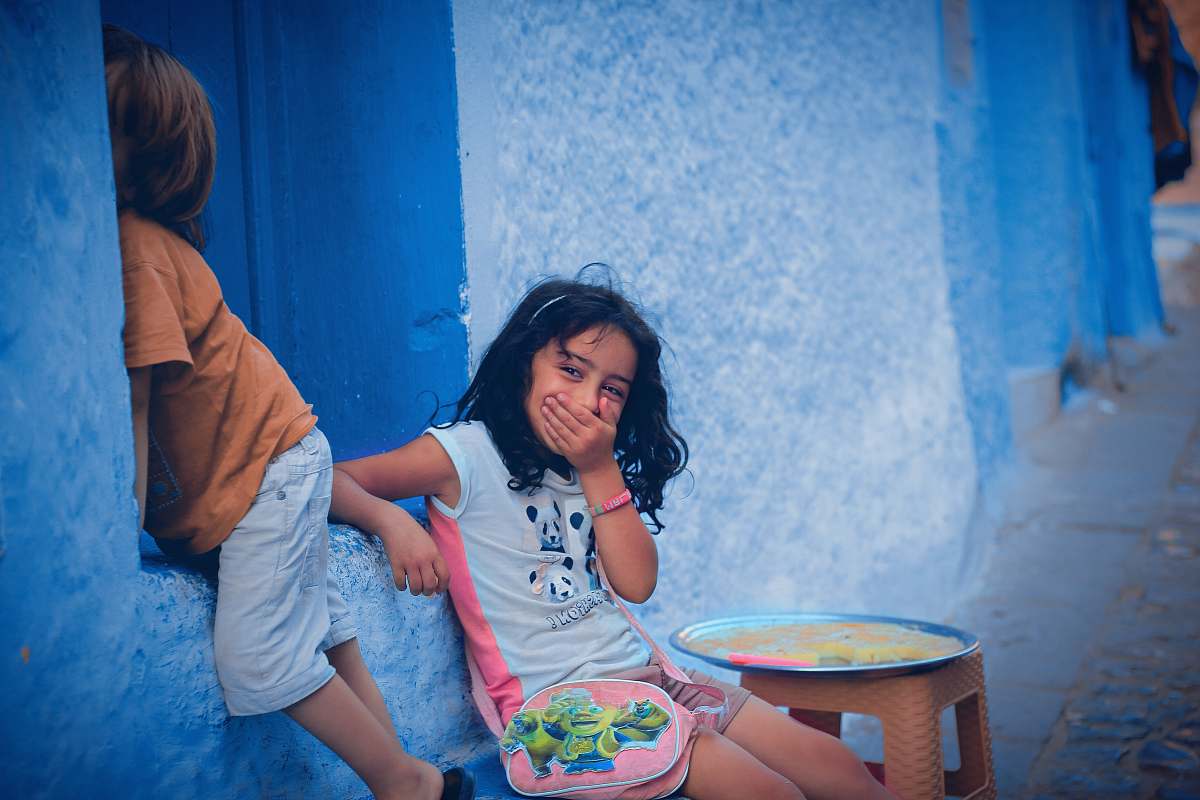 human two children leaning on blue wall people