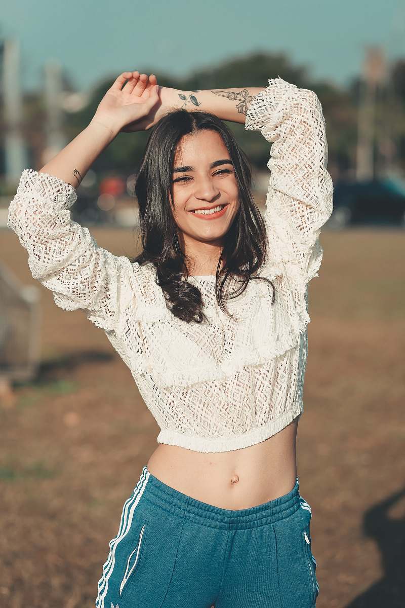 human woman in white 3/4-sleeved crop top stretching her arms people