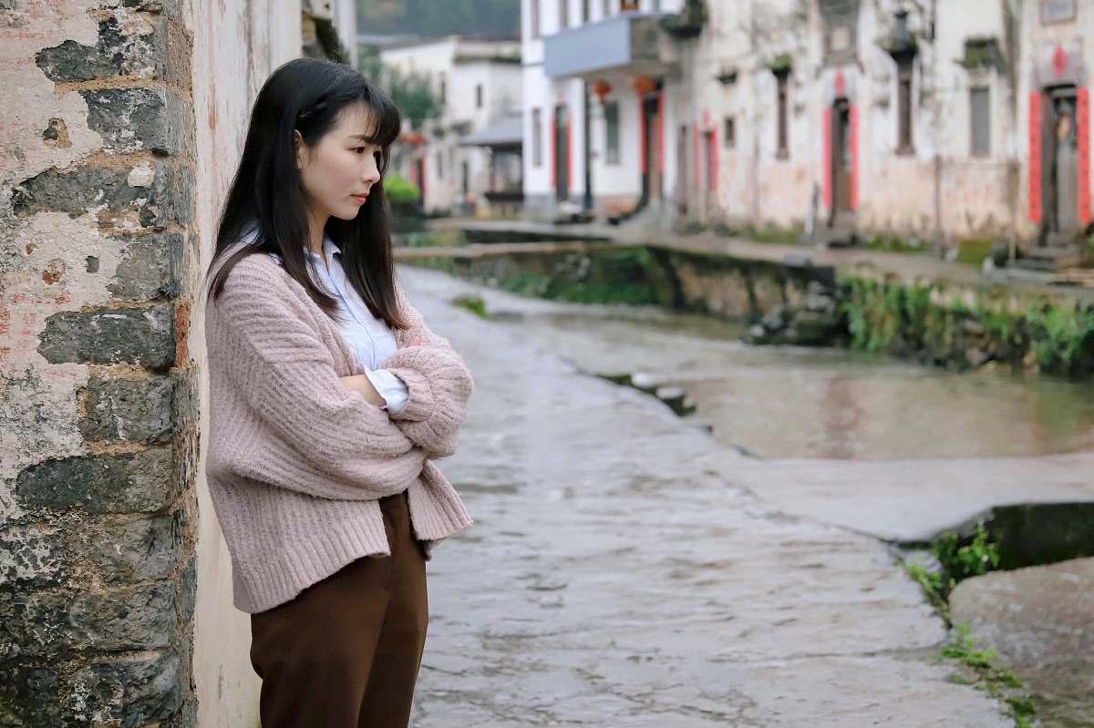 human woman leaning on beige concrete wall people