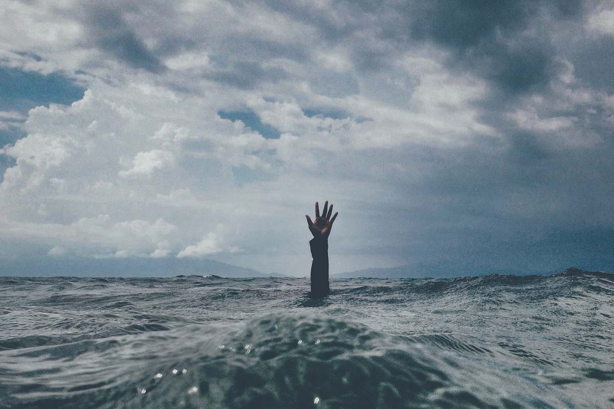 grey photo of person reach out above the water sea