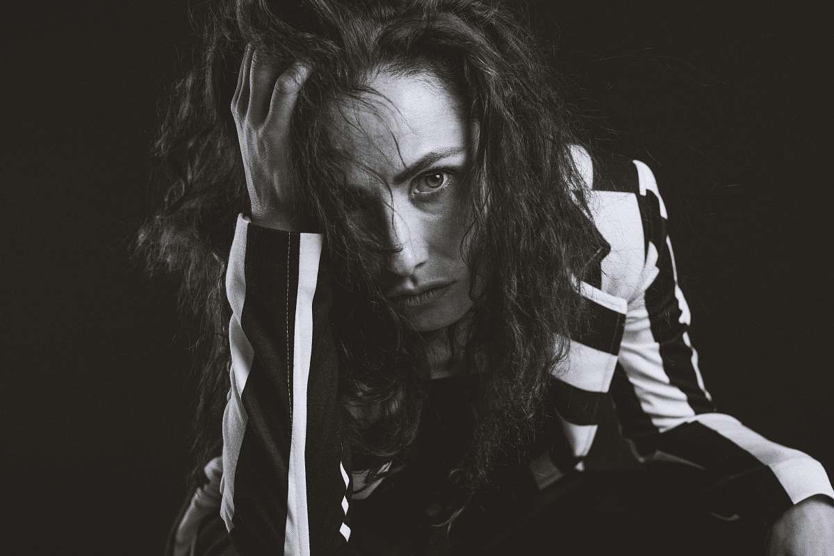 looking grayscale photo of woman with hand of head black