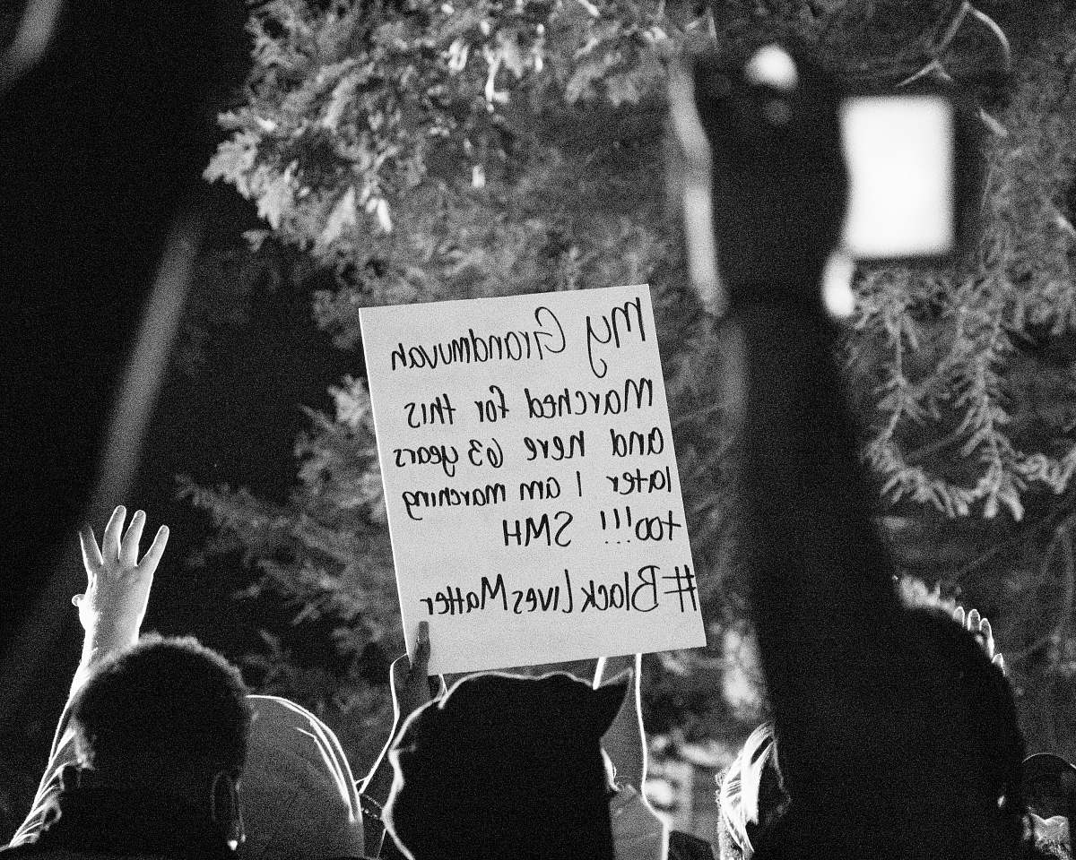grey grayscale photo of people holding signage protest