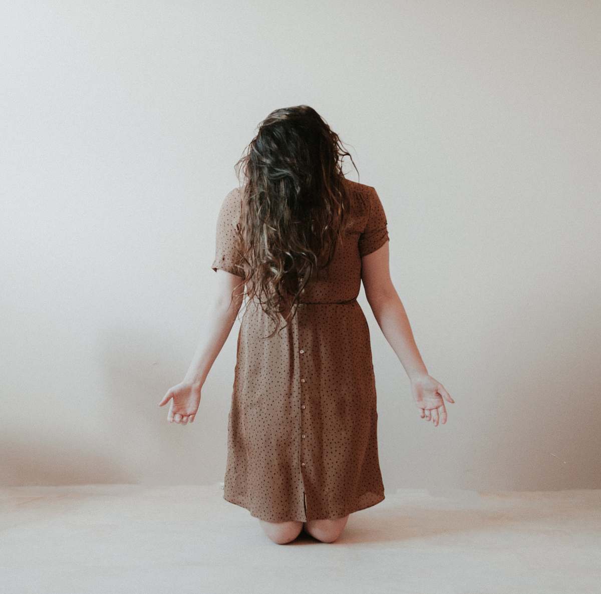 clothing kneeling woman wearing brown dress dress