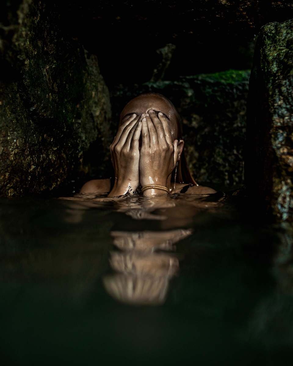worship woman on water covering her face with both hands buddha
