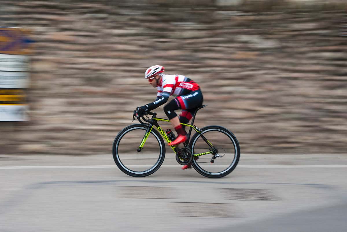 bicycle man riding green and black road bike during daytime sport