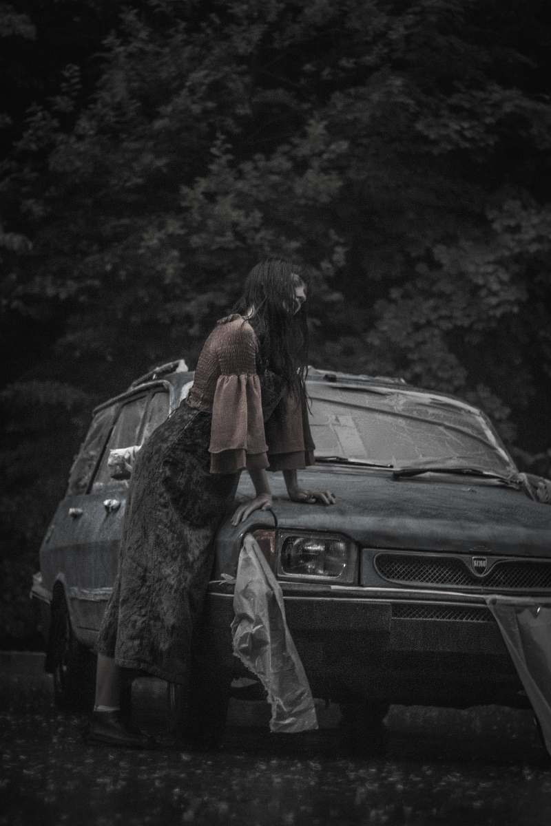 car greyscale photography of woman beside vehicle automobile