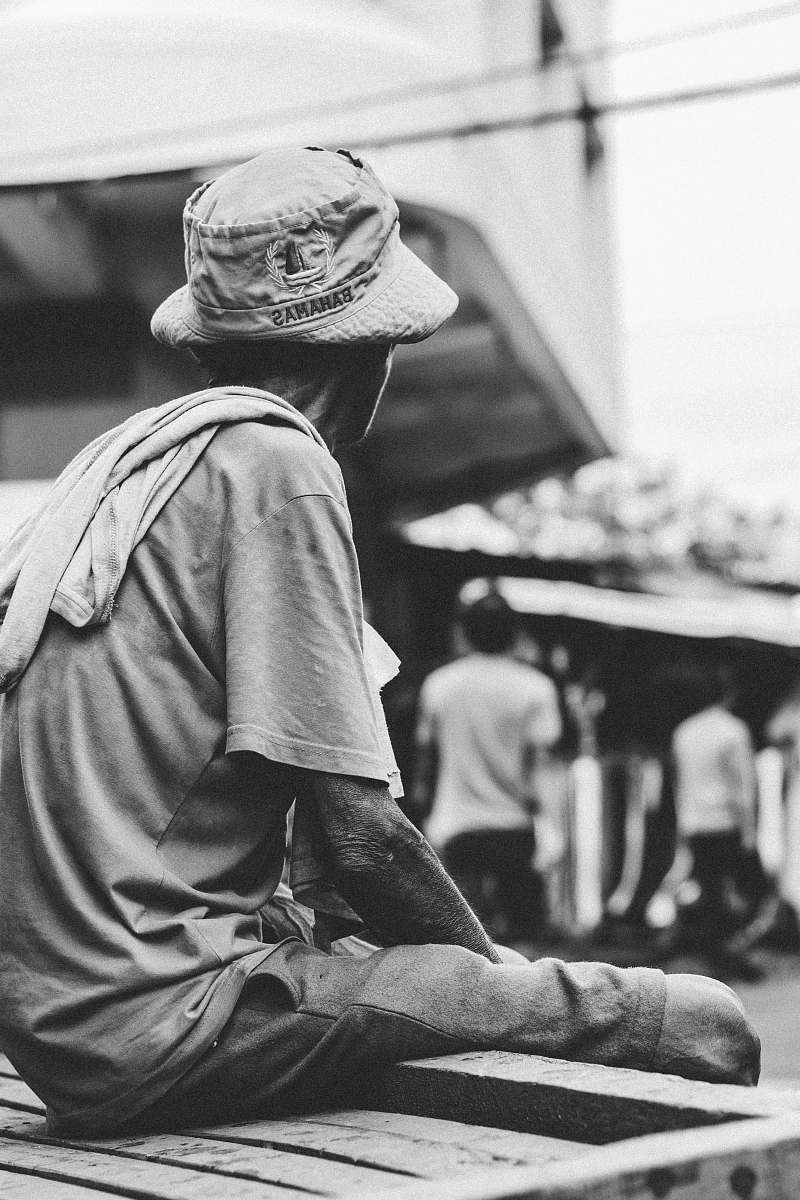 apparel man sitting on brown wooden box hat