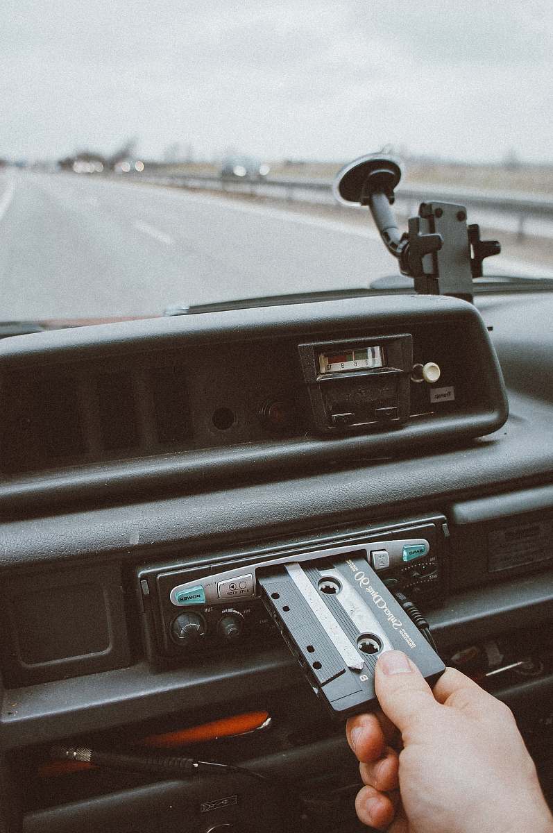 roadtrip person inserting cassette tape on cassette player tape