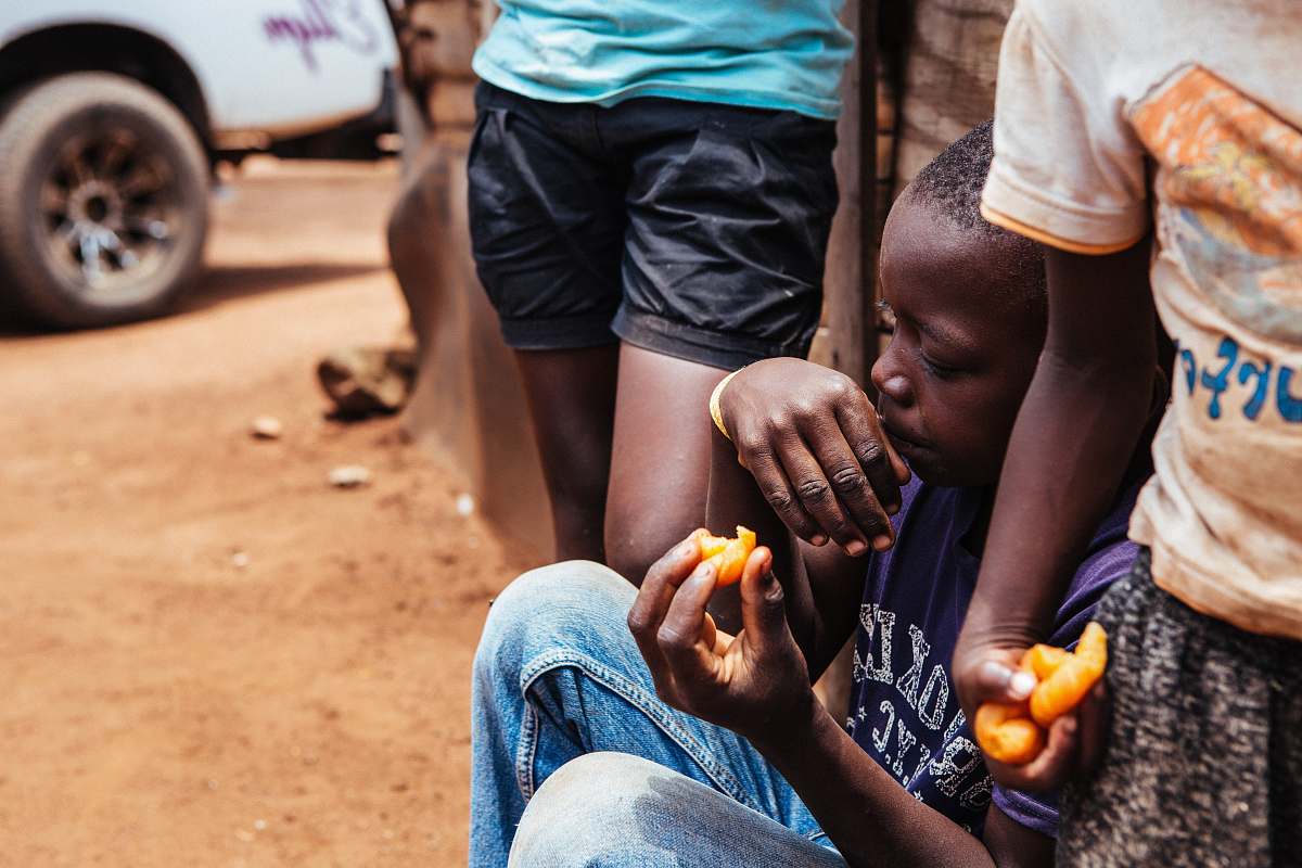 person boy sitting while holding food during daytime car