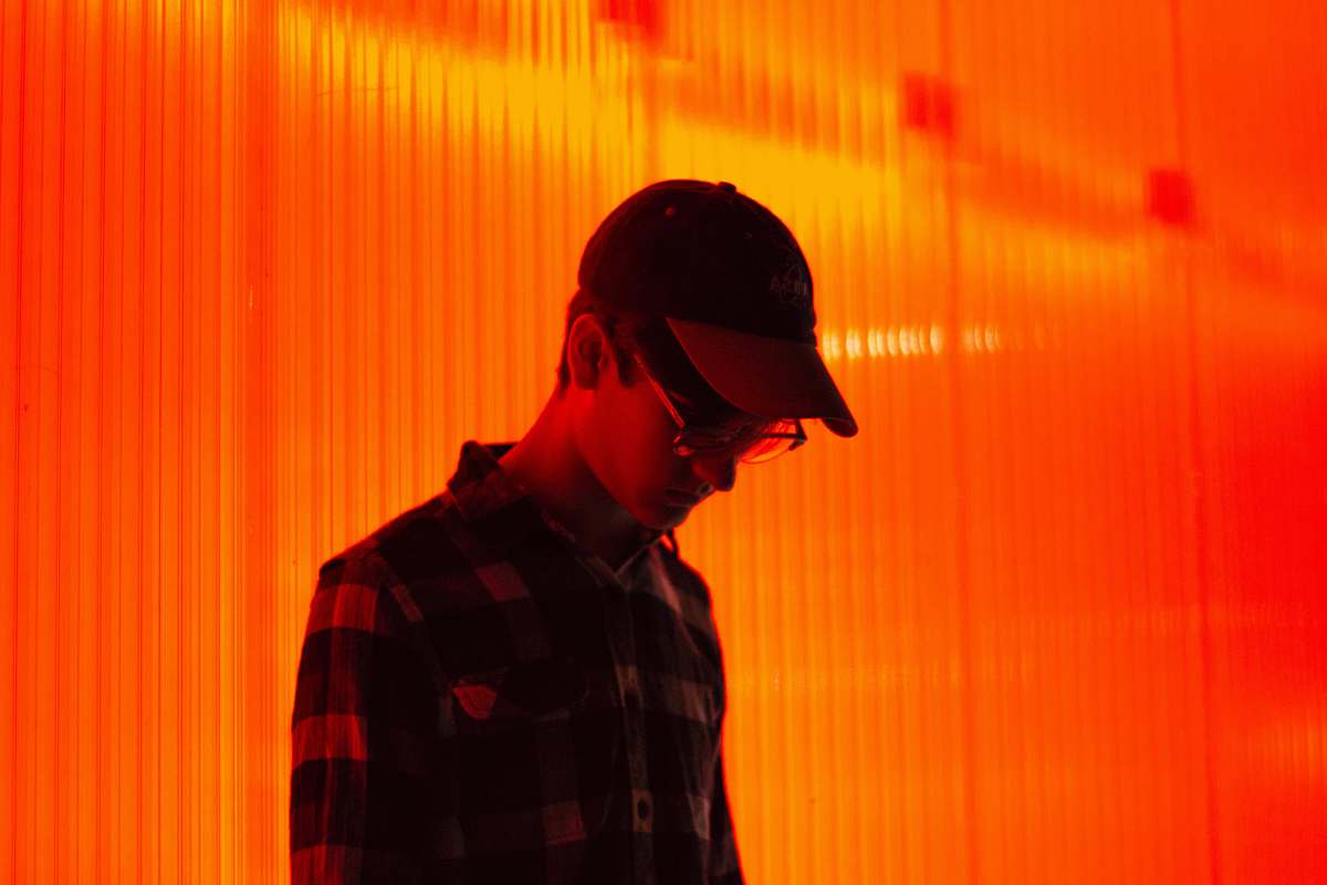 person person wearing cap standing on orange wall people