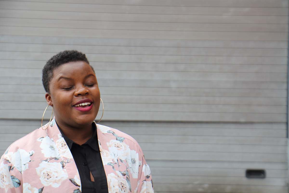 person woman wearing pink blazer smile