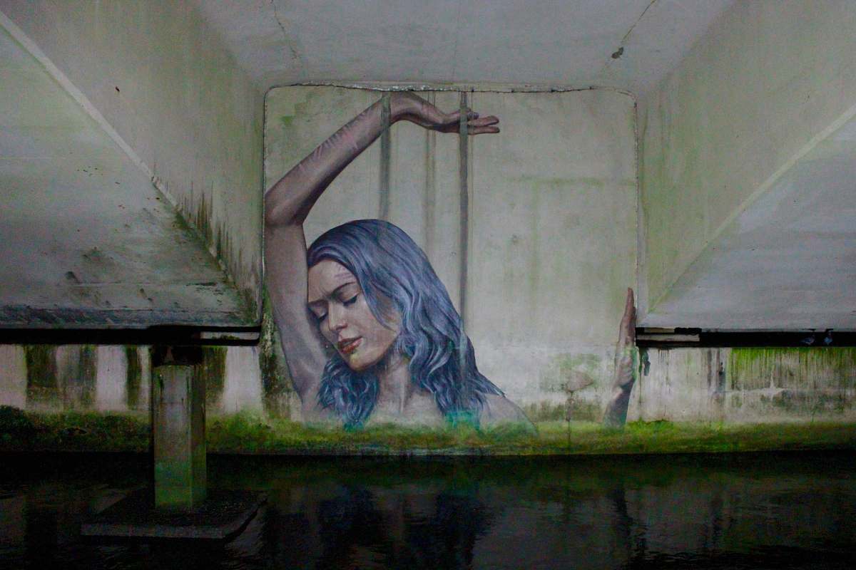 mural blue-haired woman with left hand on hair graffiti west palm beach