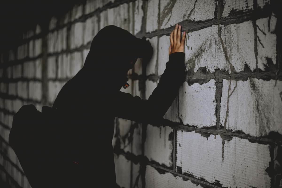 silhouette man leaning on wall brick