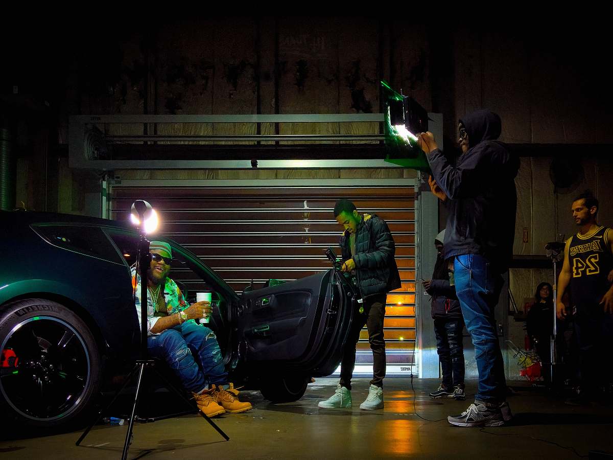 human person sitting in car with opened door near people machine