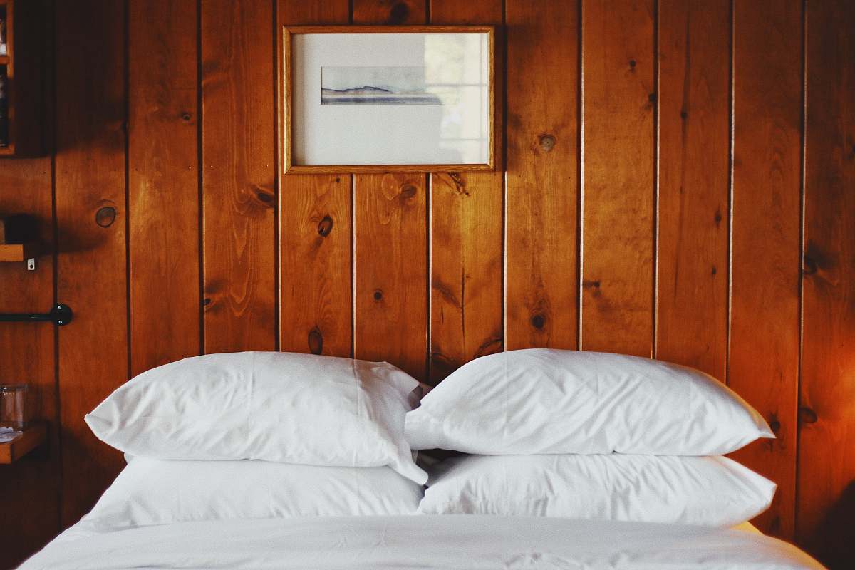 pillow four white pillows in front of brown wooden wall wood