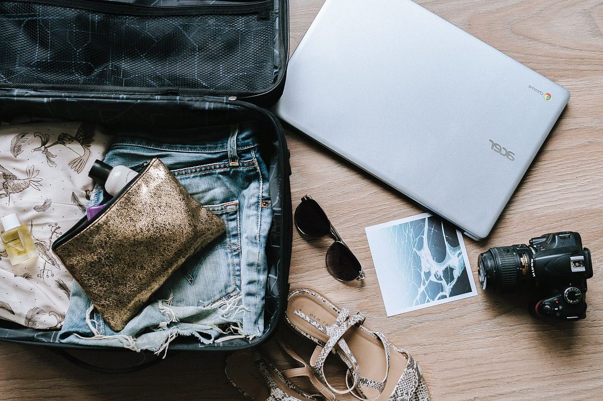 black DSLR camera near sunglasses and bag