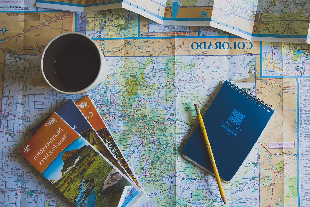 books and pencil on map
