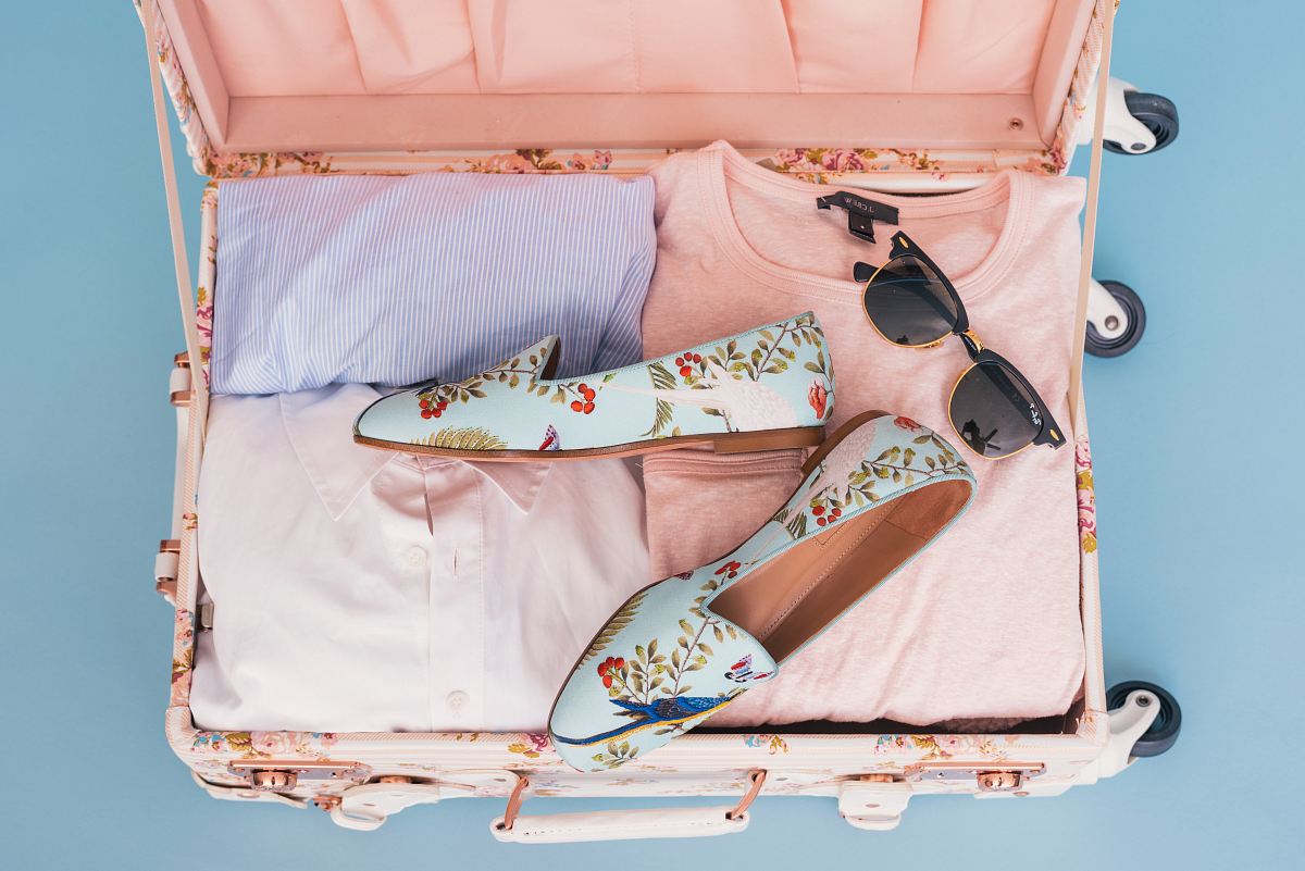clothing items and pair of shoes in luggage