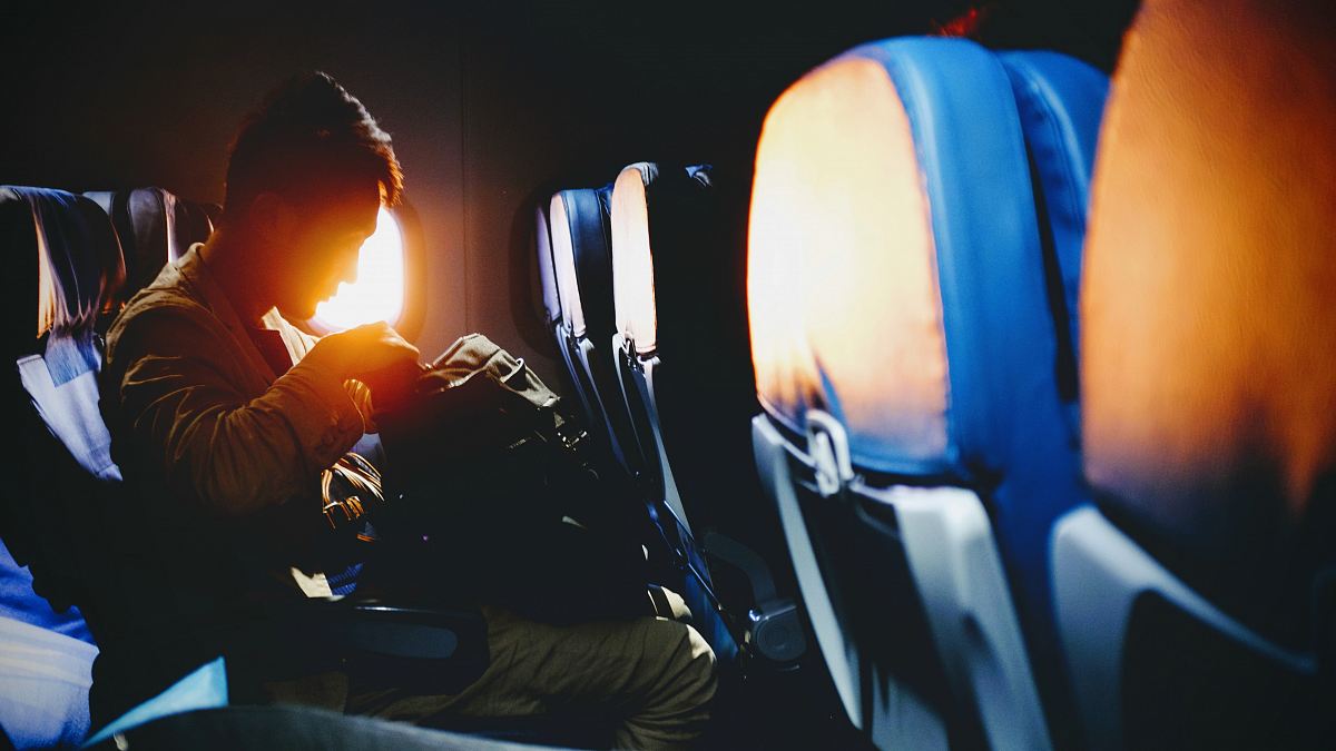 man looking on his sitting on plane seat