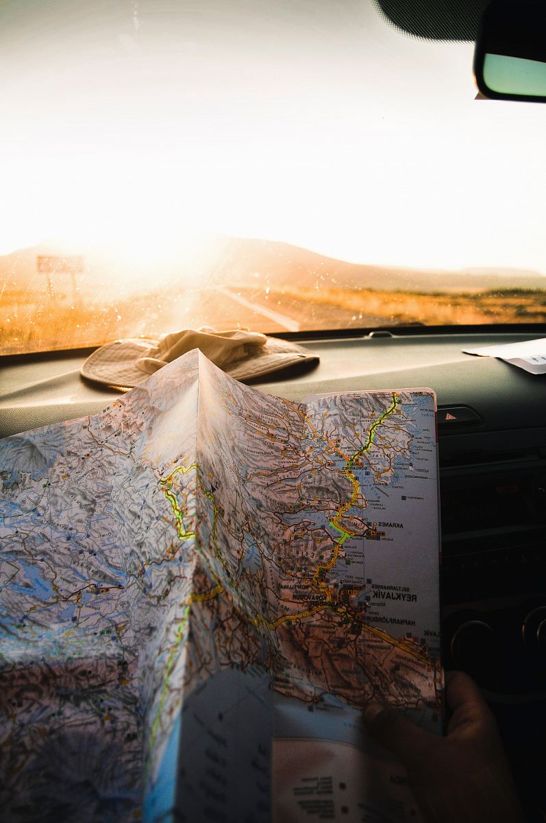 person holding blue and brown map