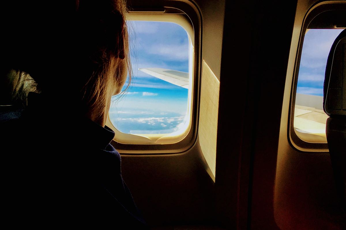 person looking outside of airplane window